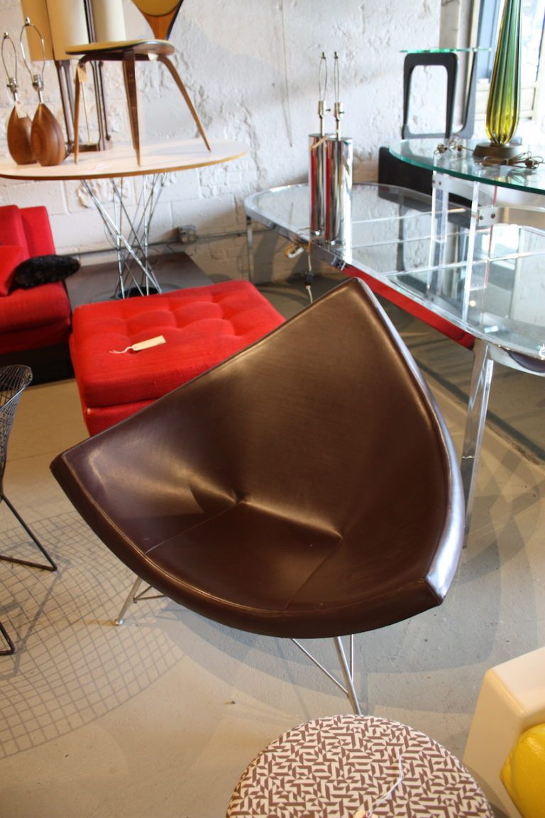 George Nelson's 1958 "Coconut" Chair is a winner for just about any space. Its triangular fiberglass body is formed into a cupped shape, cushioned and upholstered leather. The chair has three tubular aluminum legs.