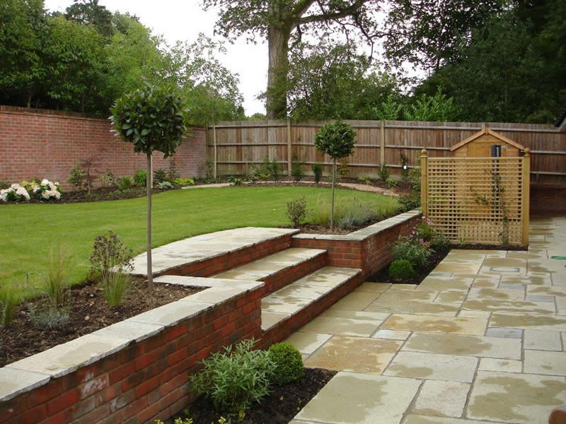 Sloping garden with pebble paving and grass